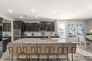 a living room with furniture a flat screen tv and a table