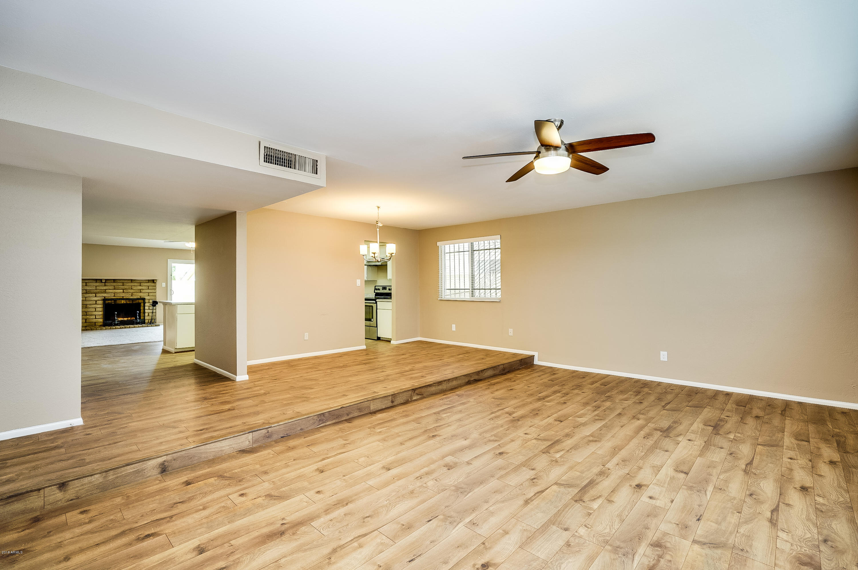 6509 West Camelback Road Phoenix, AZ 85033 - Photo 3 of 25 a view of empty room with wooden floor and fan