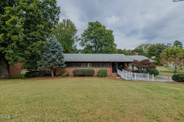 a view of a house with a yard and a tree