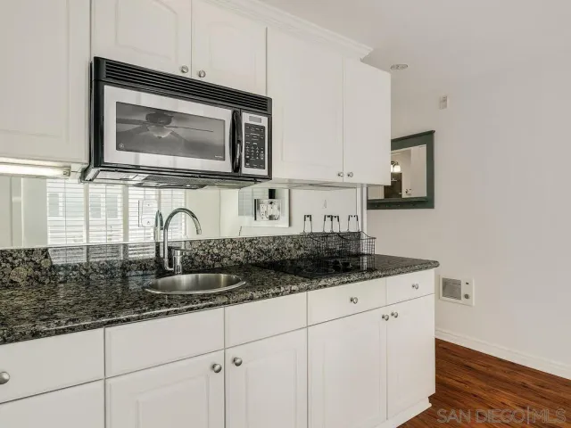 a kitchen with granite countertop a sink and a microwave