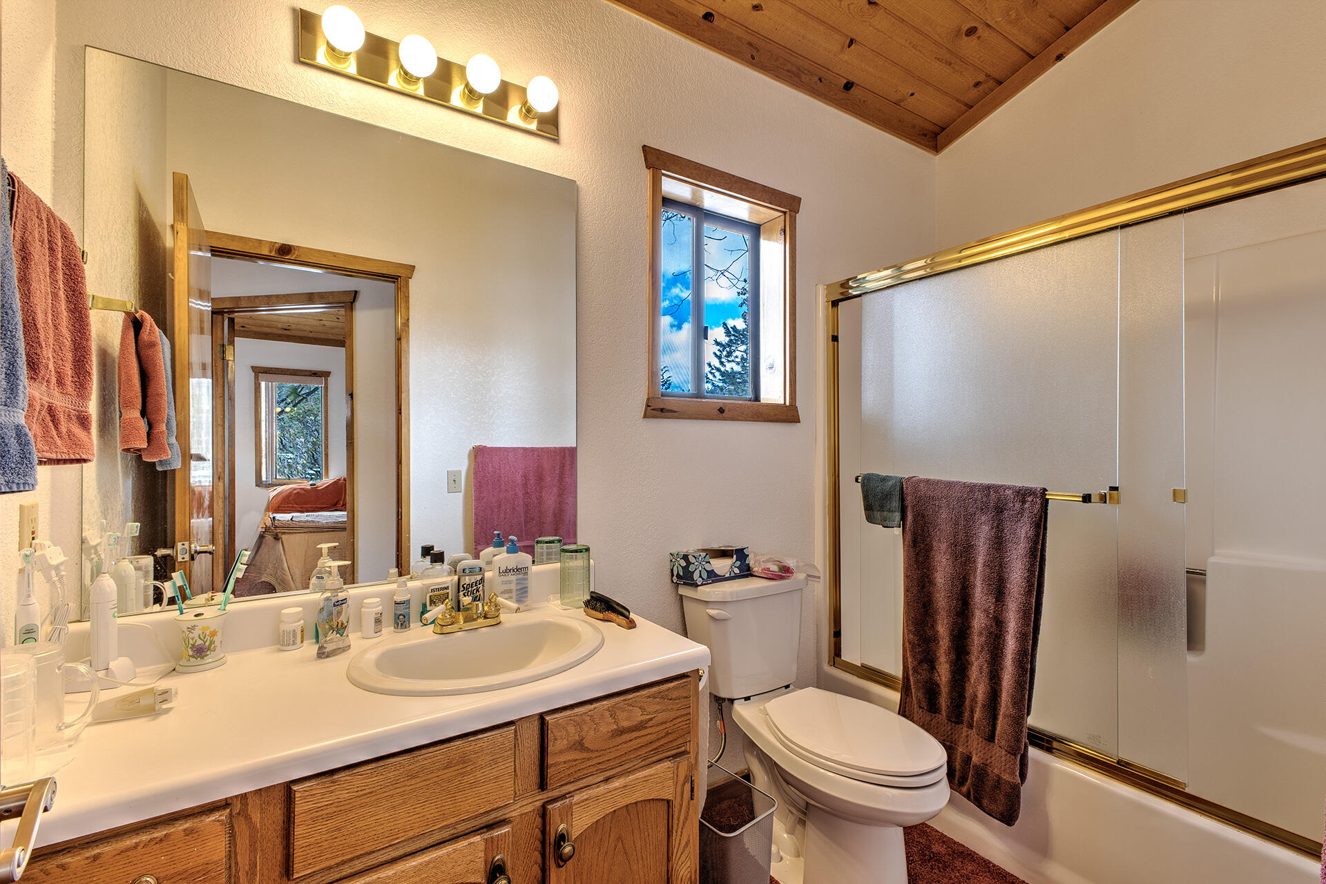 25006 Knob-Hill Idyllwild, CA 92549 - Photo 45 of 47 a bathroom with a sink a toilet a mirror a vanity and shower