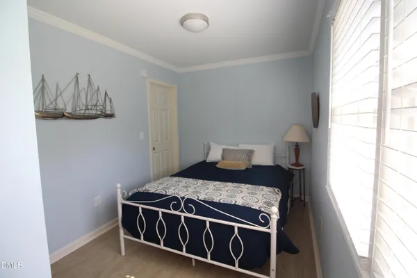 a bed sitting in a bedroom next to a window