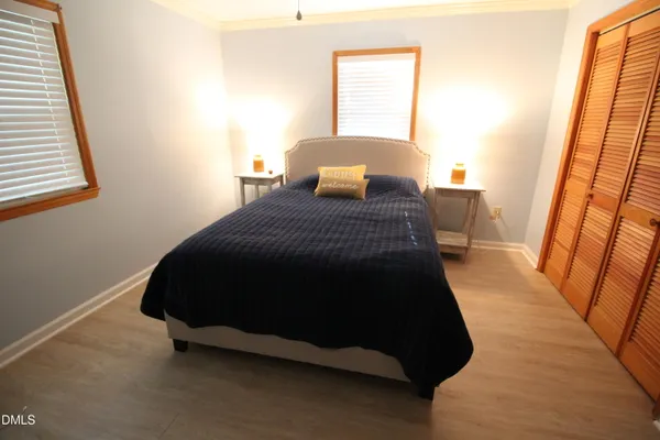 a bedroom with a bed a chair a couch and a window