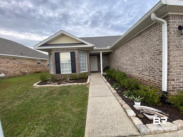 22713 Respite Lane Foley, AL 36535 - Photo 34 of 35 View of exterior entry featuring a lawn