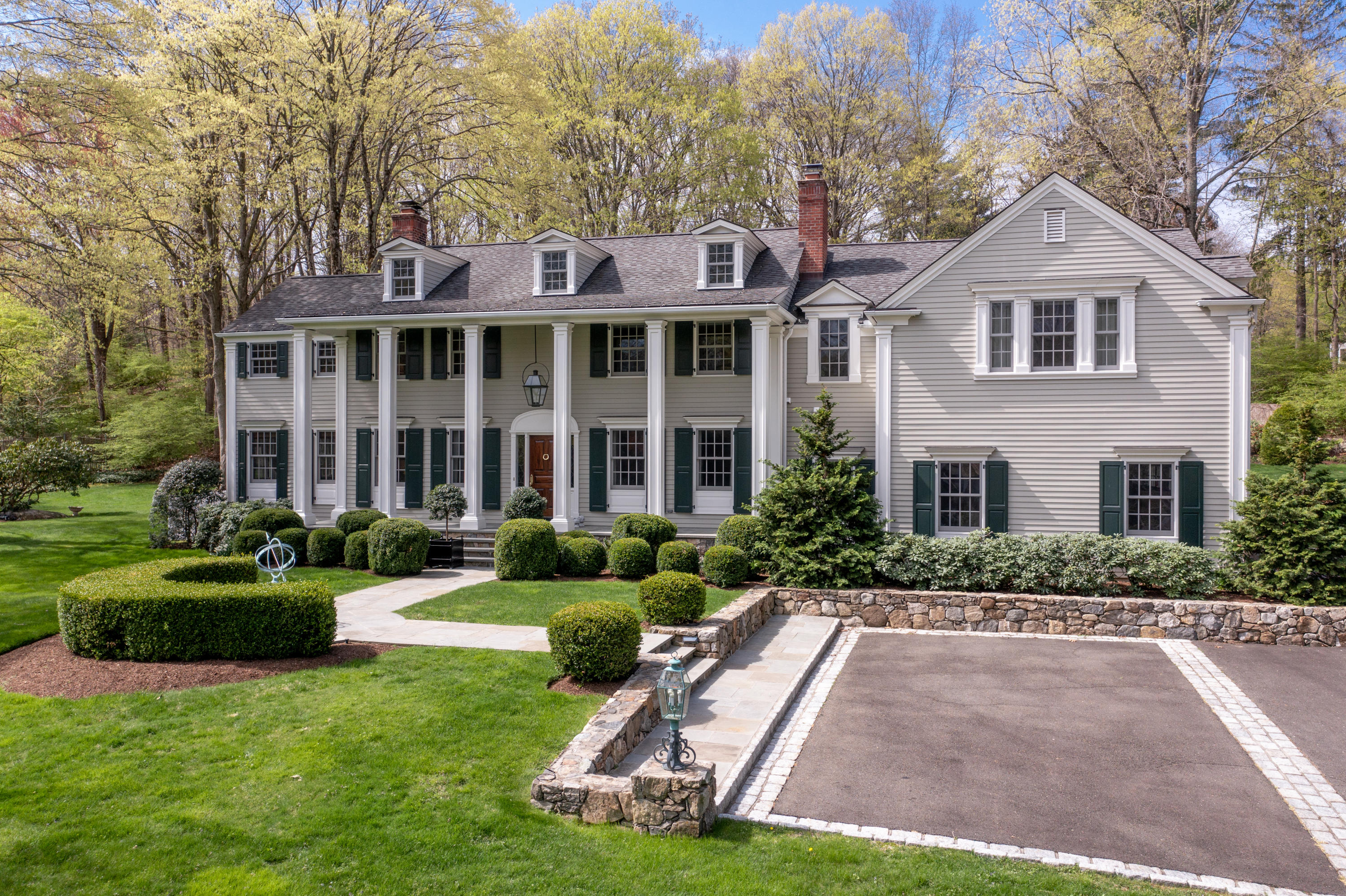 398 Valley Road New Canaan, CT 06840 - Photo 2 of 44 a front view of a house with a yard and garage