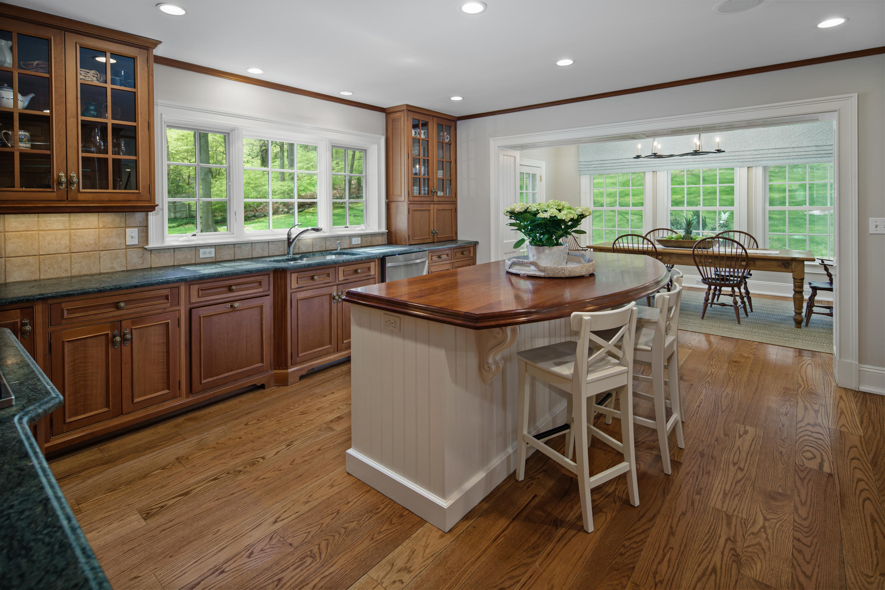 398 Valley Road New Canaan, CT 06840 - Photo 11 of 44 a kitchen with stainless steel appliances granite countertop wooden floor window and chairs