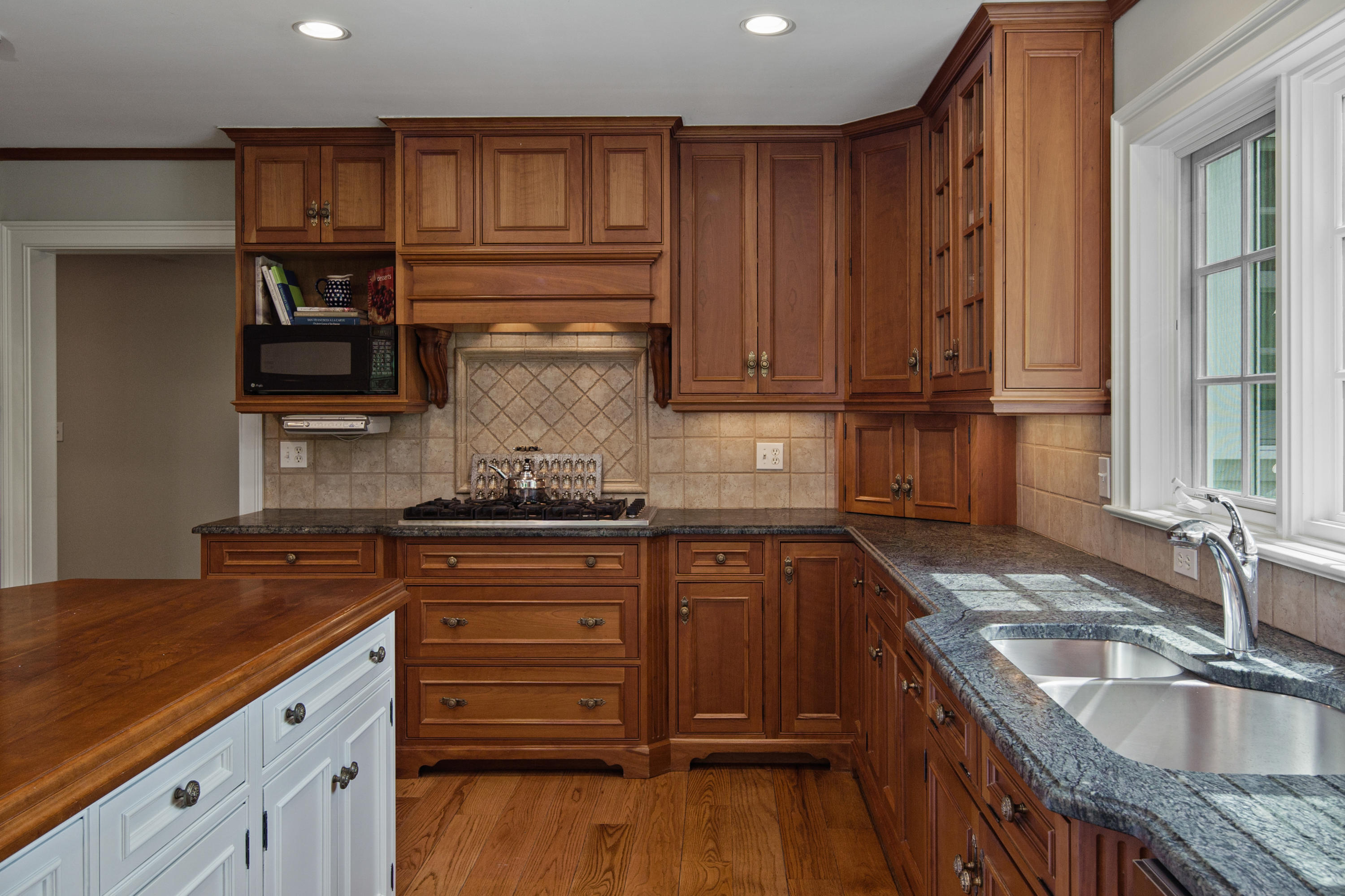 398 Valley Road New Canaan, CT 06840 - Photo 12 of 44 a kitchen with granite countertop wooden cabinets a sink and dishwasher