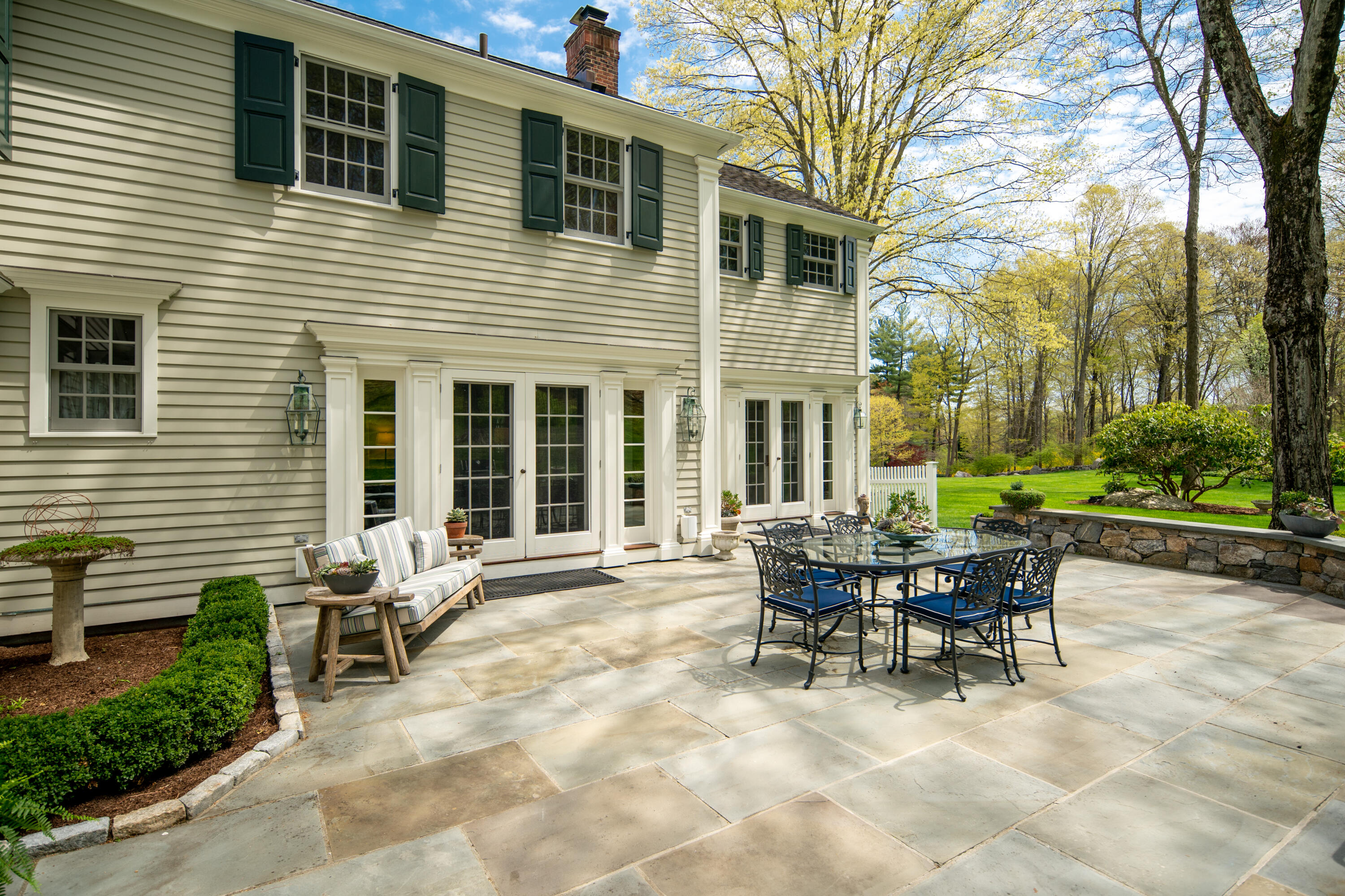 398 Valley Road New Canaan, CT 06840 - Photo 4 of 44 a patio with a table and chairs and potted plants