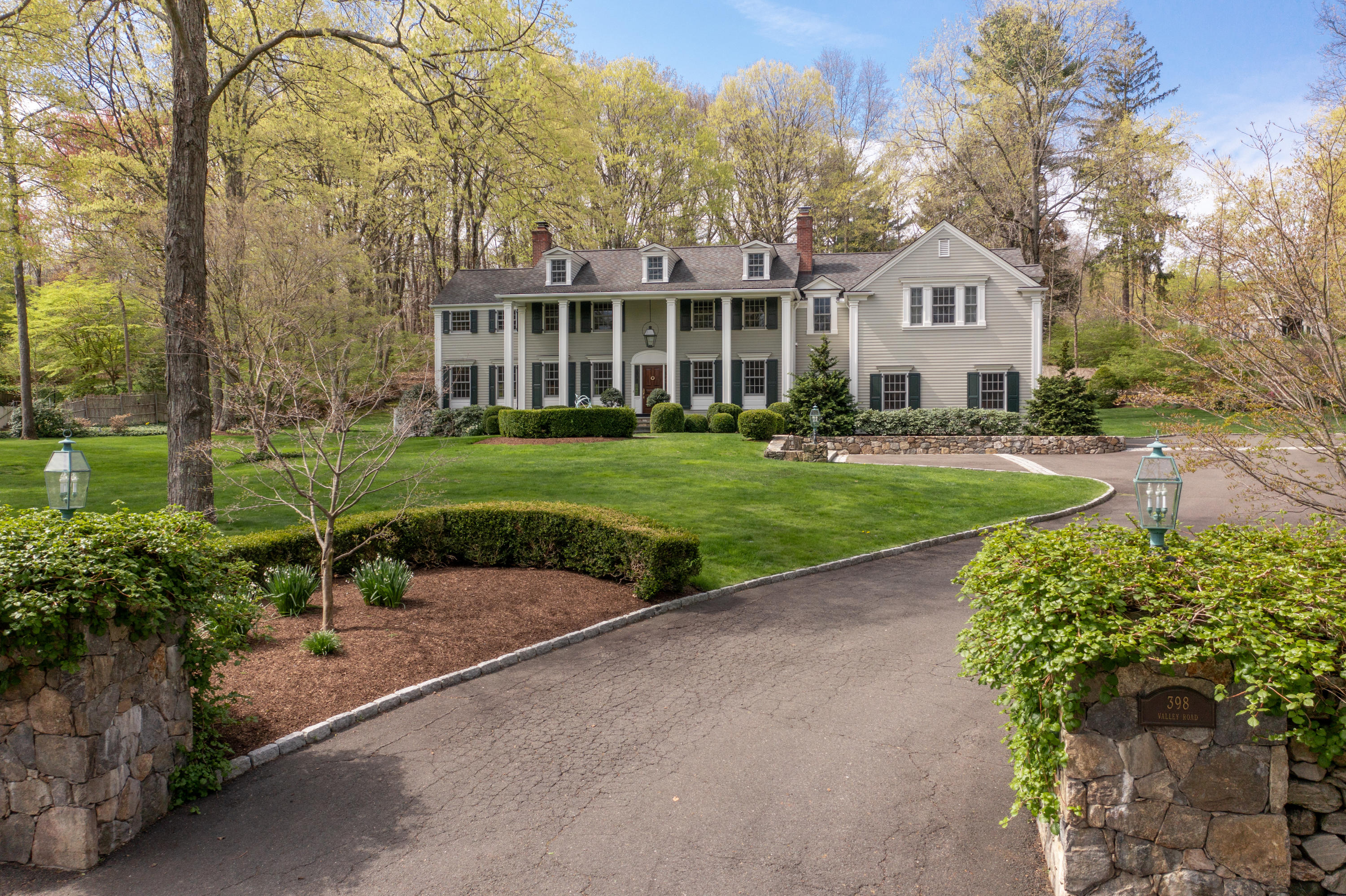 398 Valley Road New Canaan, CT 06840 - Photo 40 of 44 a front view of a house with a yard and garage