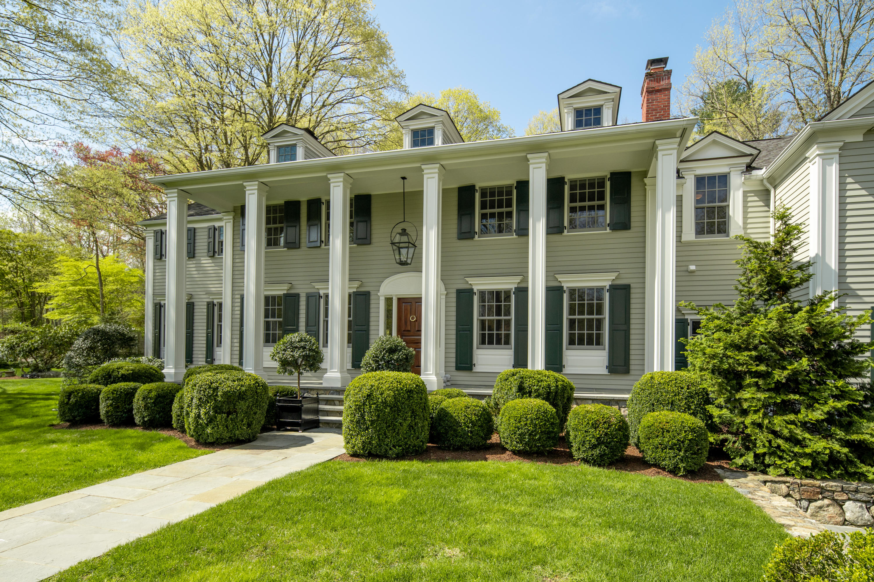 398 Valley Road New Canaan, CT 06840 - Photo 41 of 44 a view of a house with a garden and plants and large trees