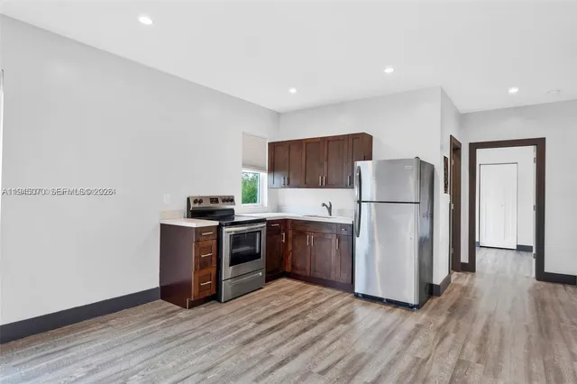 a kitchen with a refrigerator sink and wooden cabinets