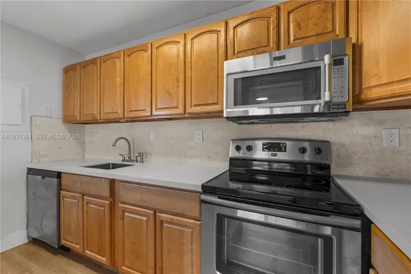 a kitchen with stainless steel appliances granite countertop a stove microwave and sink