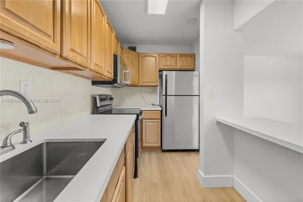 a kitchen with a sink a refrigerator and cabinets
