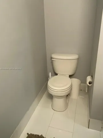 a white toilet sitting next to a white wall