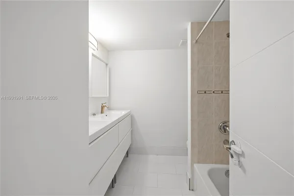 a bathroom with a tub sink and mirror