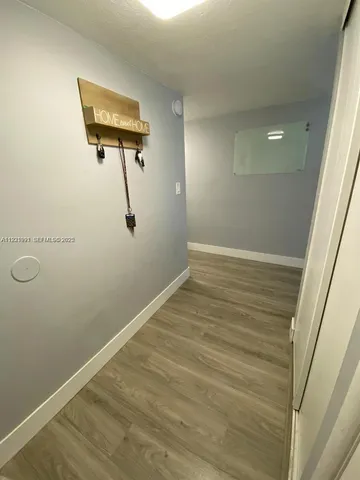 a view of a room with wooden floor and white walls
