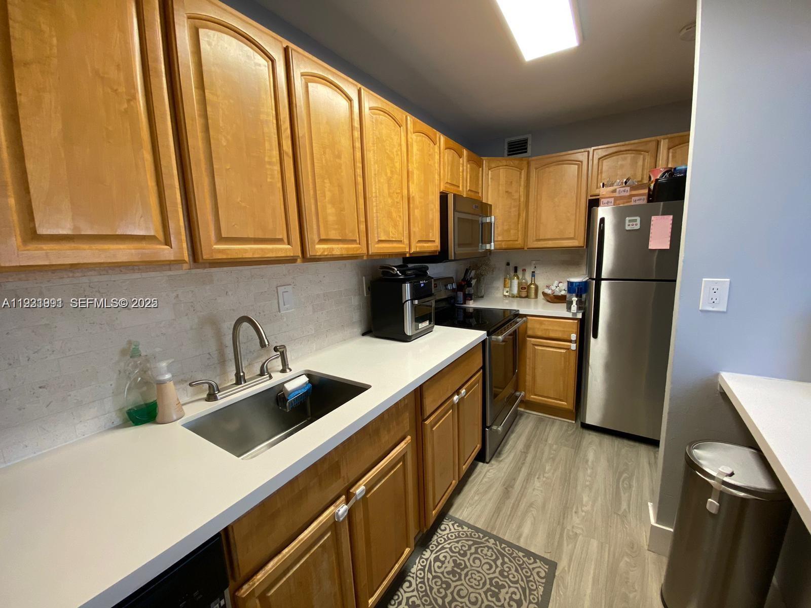 455 South Pine Island Road, Unit 307C Plantation, FL 33324 - Photo 9 of 17 a kitchen with a sink a refrigerator a window and cabinets