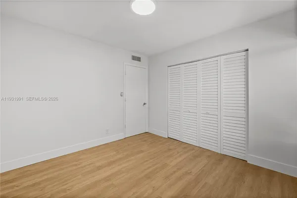 a view of empty room with wooden floor
