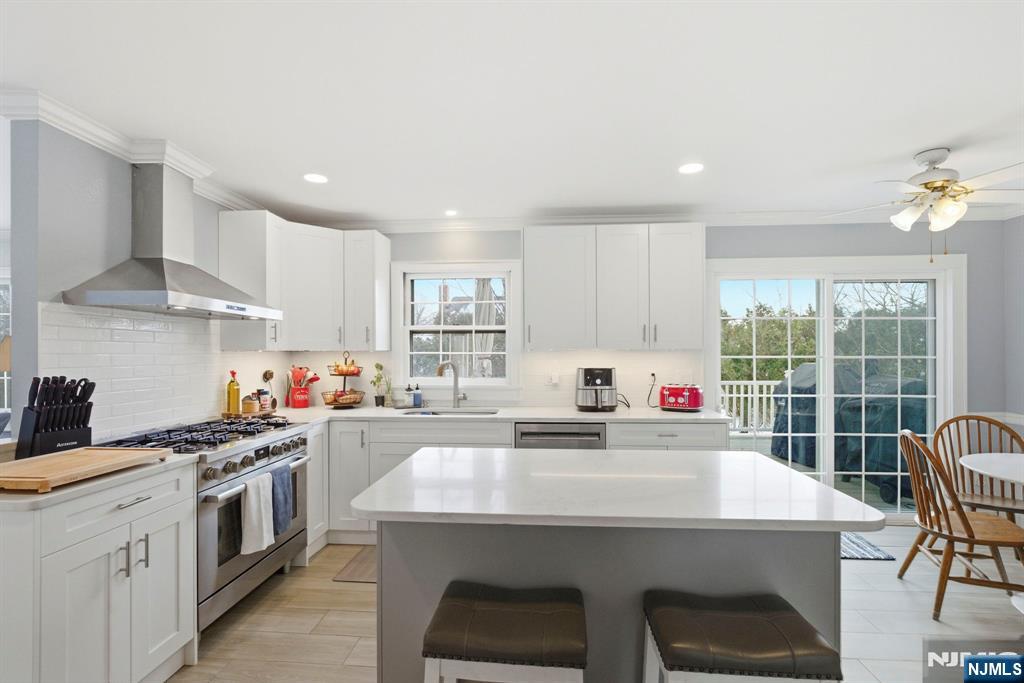 18 Laura Lane Park Ridge, NJ 07656 - Photo 11 of 36 a kitchen with kitchen island a stove a sink a dining table and chairs