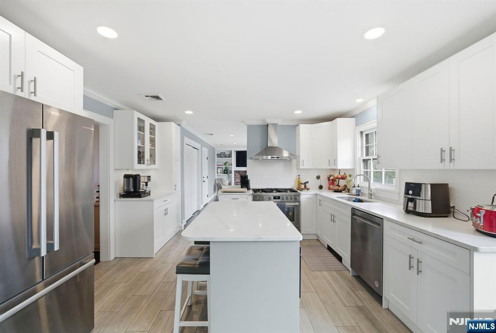 18 Laura Lane Park Ridge, NJ 07656 - Photo 13 of 36 a kitchen with white cabinets and stainless steel appliances