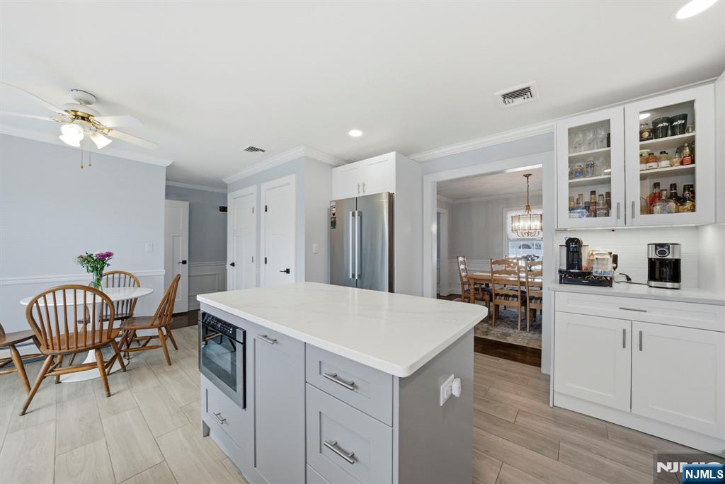 18 Laura Lane Park Ridge, NJ 07656 - Photo 15 of 36 a open kitchen with a refrigerator a sink dishwasher a dining table and chairs with wooden floor