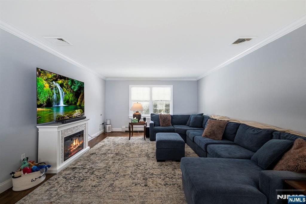 18 Laura Lane Park Ridge, NJ 07656 - Photo 6 of 36 a living room with furniture a flat screen tv and a fireplace