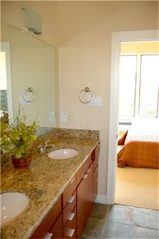 a bathroom with a granite countertop sink and a mirror