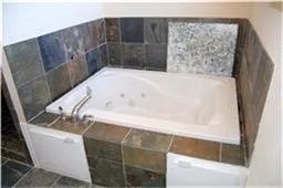 a bath tub sitting in a bathroom next to a sink