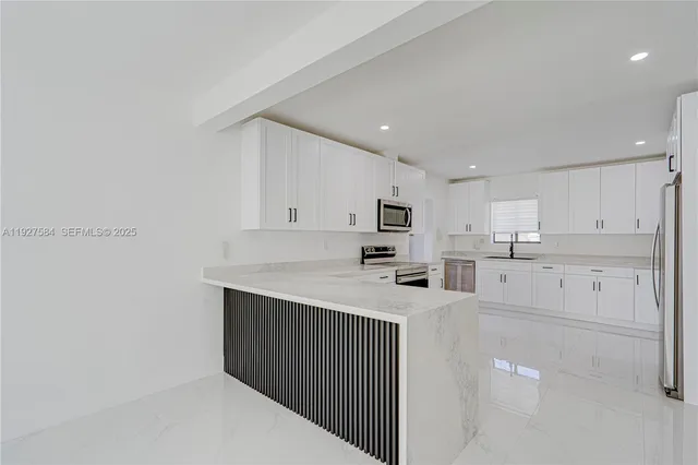 a kitchen with stainless steel appliances a refrigerator sink and white cabinets