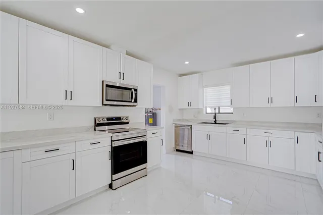 a kitchen with granite countertop white cabinets stainless steel appliances and sink