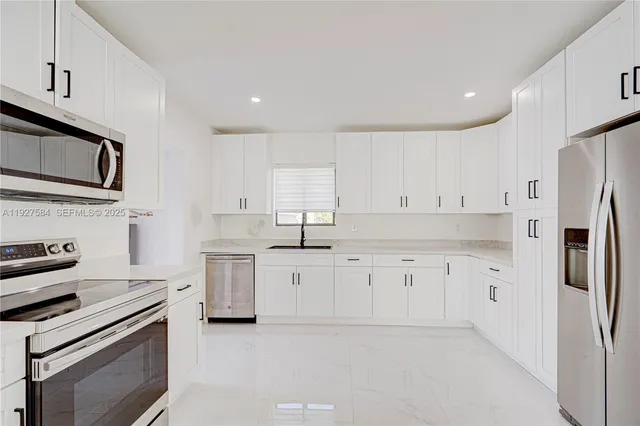 a kitchen with granite countertop cabinets stainless steel appliances and a counter space