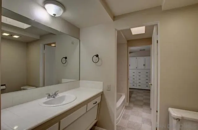 a bathroom with a double vanity sink a mirror a bathtub and