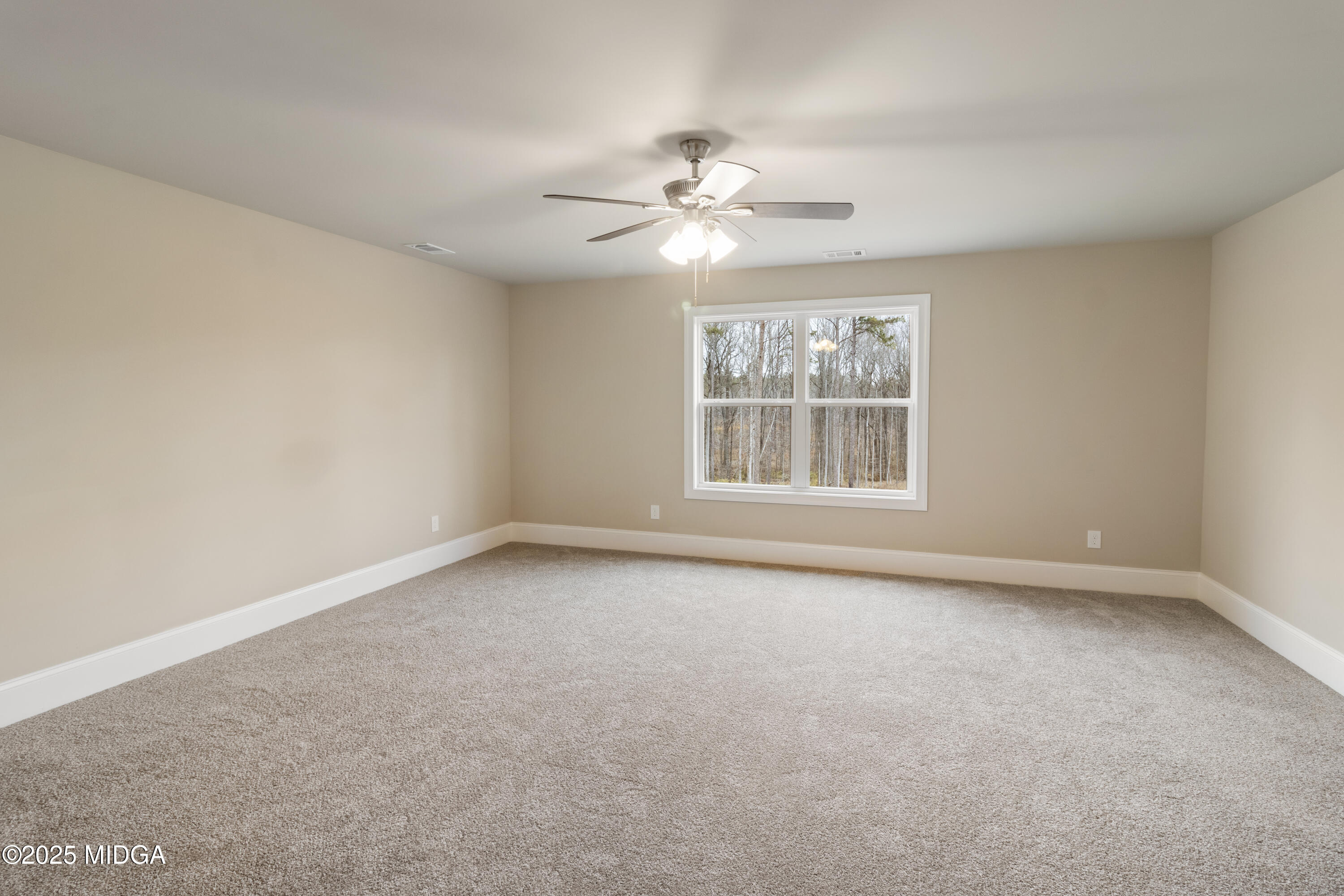 703 Giles Road Forsyth, GA 31029 - Photo 18 of 30 an empty room with a window and ceiling fan