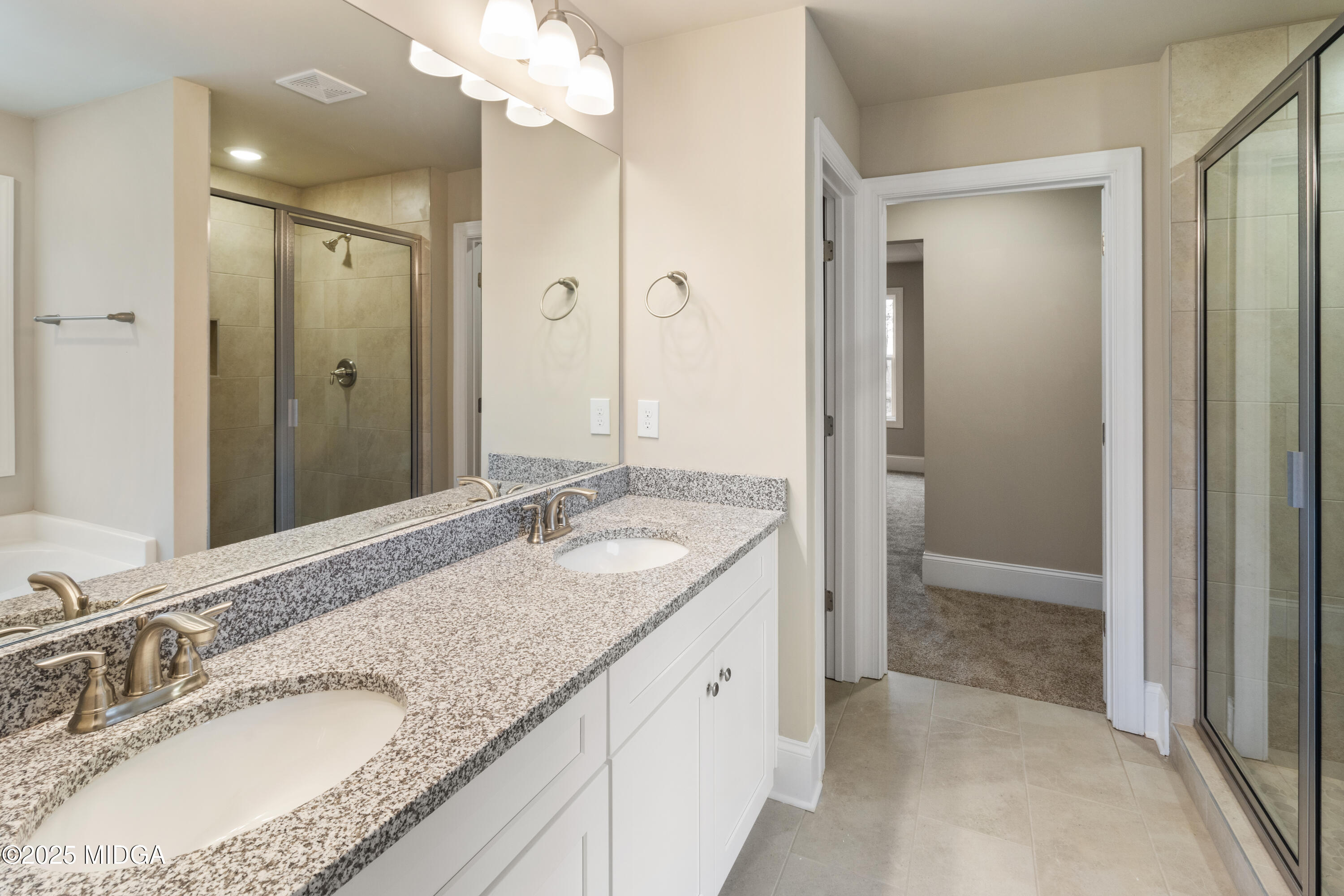 703 Giles Road Forsyth, GA 31029 - Photo 20 of 30 a bathroom with a granite countertop double vanity sink mirror and shower