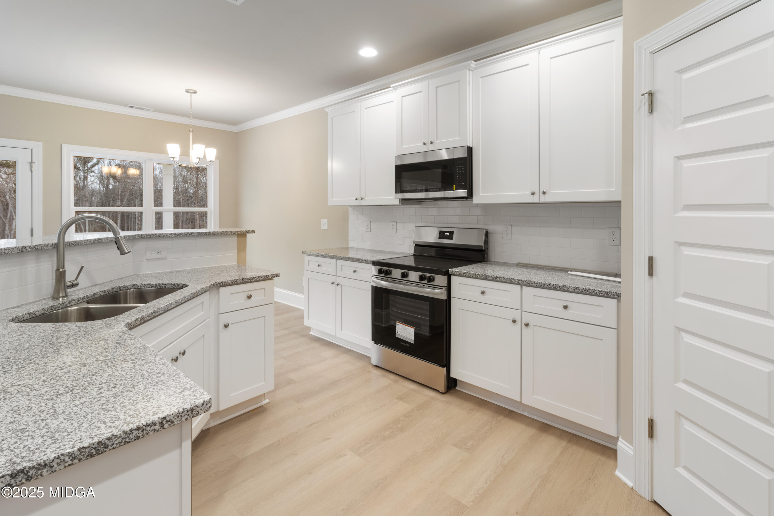 703 Giles Road Forsyth, GA 31029 - Photo 8 of 30 a kitchen with granite countertop white cabinets sink and stainless steel appliances
