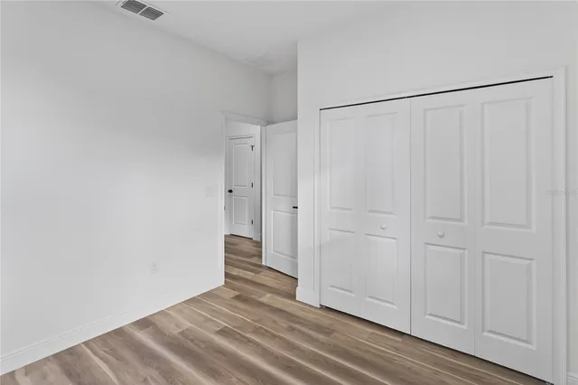 a view of a closet area with hardwood