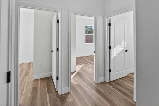 a view of a hallway with wooden floor and staircase
