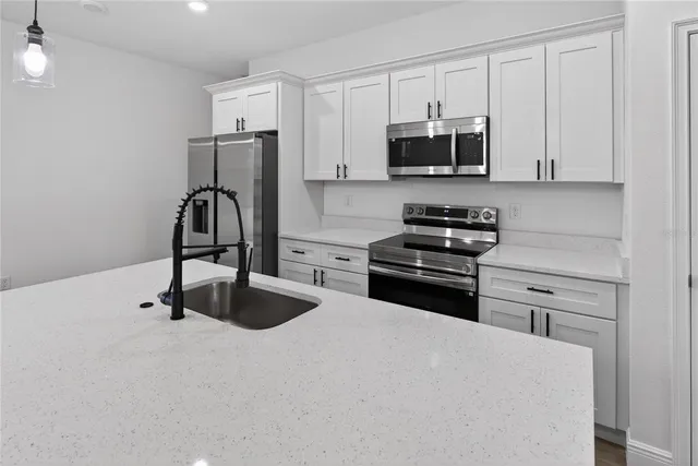 a kitchen with granite countertop a stove and a microwave