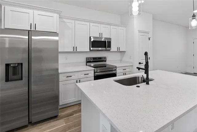 a kitchen with a refrigerator sink and cabinets