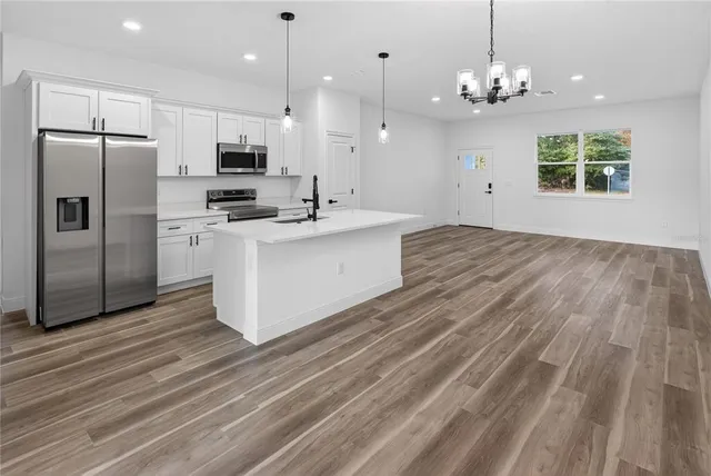 a large kitchen with kitchen island a sink stainless steel appliances and cabinets