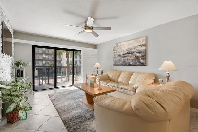 a living room with furniture and a large window with potted plants
