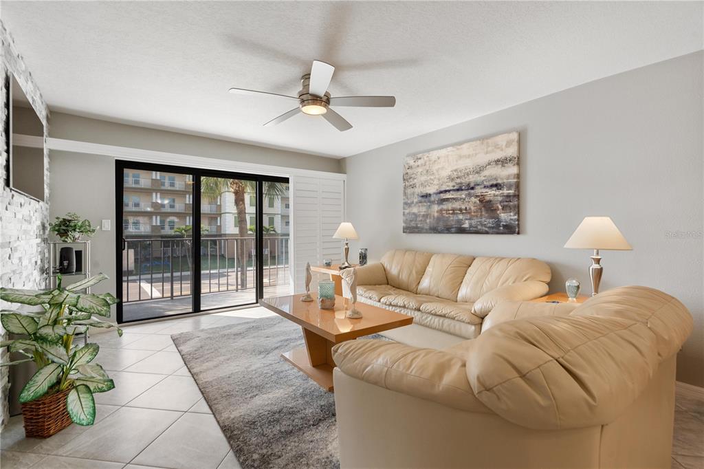 14001 Gulf Boulevard, Unit 201 Madeira Beach, FL 33708 - Photo 11 of 36 a living room with furniture and a large window with potted plants
