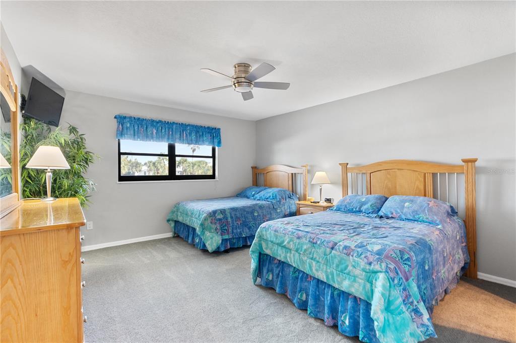 14001 Gulf Boulevard, Unit 201 Madeira Beach, FL 33708 - Photo 22 of 36 a bedroom with two beds and a chandelier