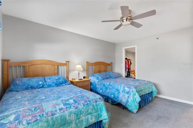 a bedroom with two beds and ceiling fan