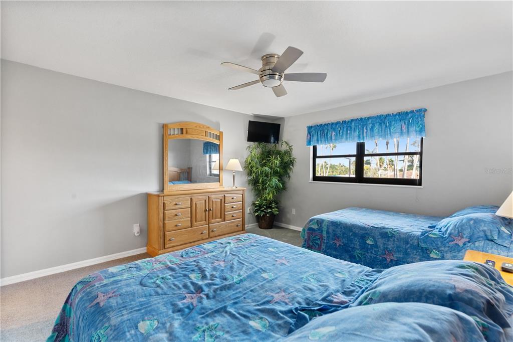 14001 Gulf Boulevard, Unit 201 Madeira Beach, FL 33708 - Photo 24 of 36 a bedroom with a large bed and a dresser