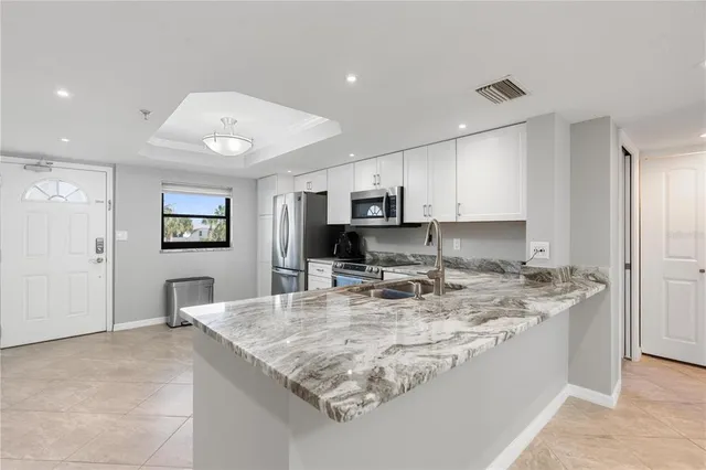 a large kitchen with kitchen island a sink appliances and a counter top space