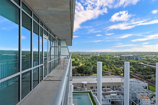 a view of a balcony with floor to ceiling windows with wooden fence