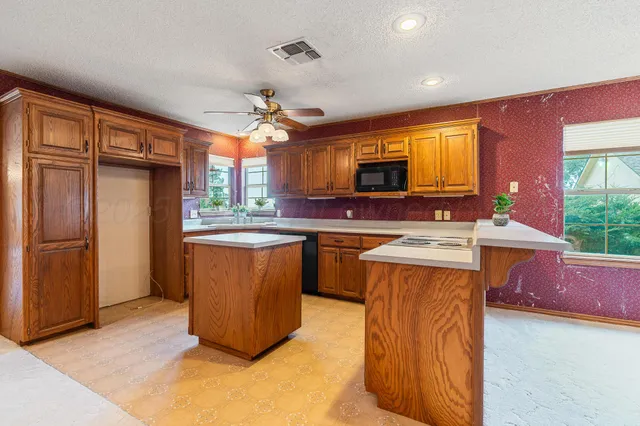 a kitchen with stainless steel appliances granite countertop a stove a sink a refrigerator and a microwave
