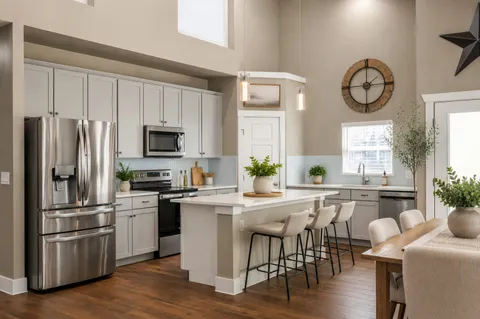 a kitchen with a table chairs microwave and cabinets