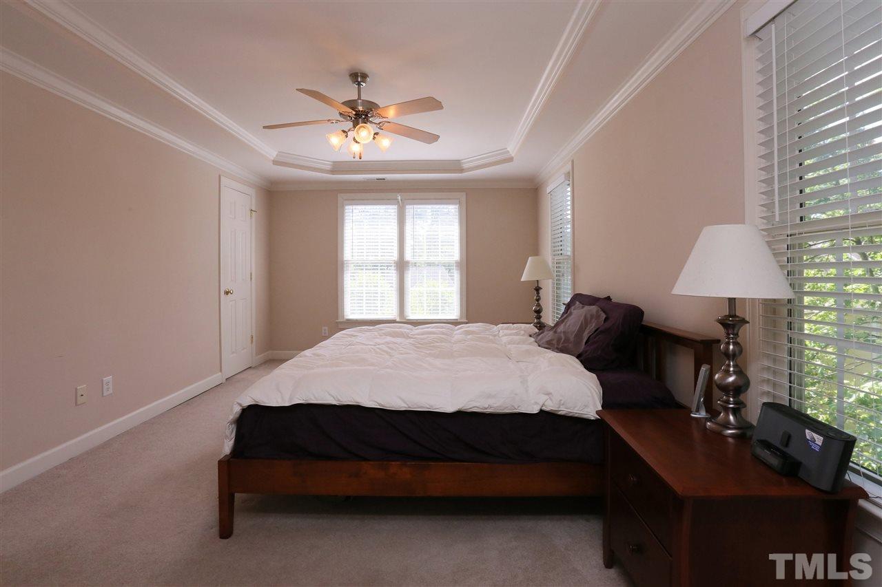 6729 Hammersmith Drive Raleigh, NC 27613 - Photo 10 of 21 a bedroom with a bed and a chandelier